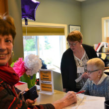 Sada Ross, left, gets help from Operations Manager Mary Gibbs, center, and Genevieve Moyer, at reception.