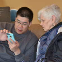 Suzanne gets a little help with her smart phone during Technology Tutoring.