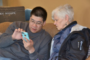Suzanne gets a little help with her smart phone during Technology Tutoring.