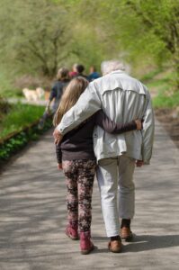 Youn person and old person arm in arm