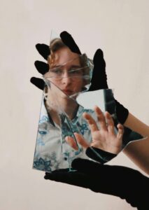 gloved hands hold image of woman in broken glass